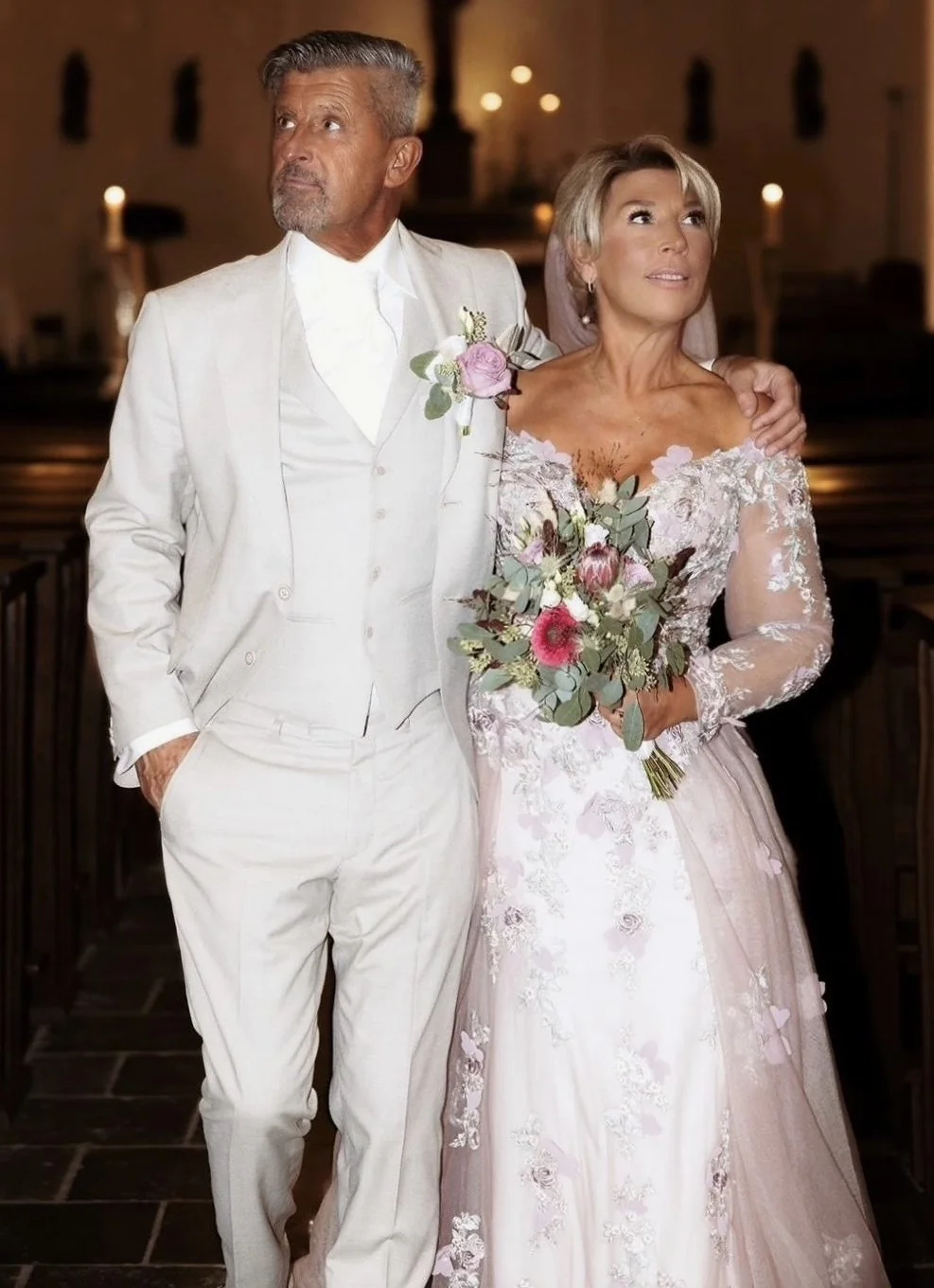 Bruidspaar in de kerk, de bruid in een jurk met lila kant