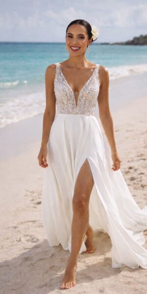 bruid op het strand in een trouwjurk met split