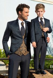 Donkerblauw Enzo Romano trouwpak met goudkleurig jacquard gilet en bijpassend kinderpak, gedragen door bruidegom en kind